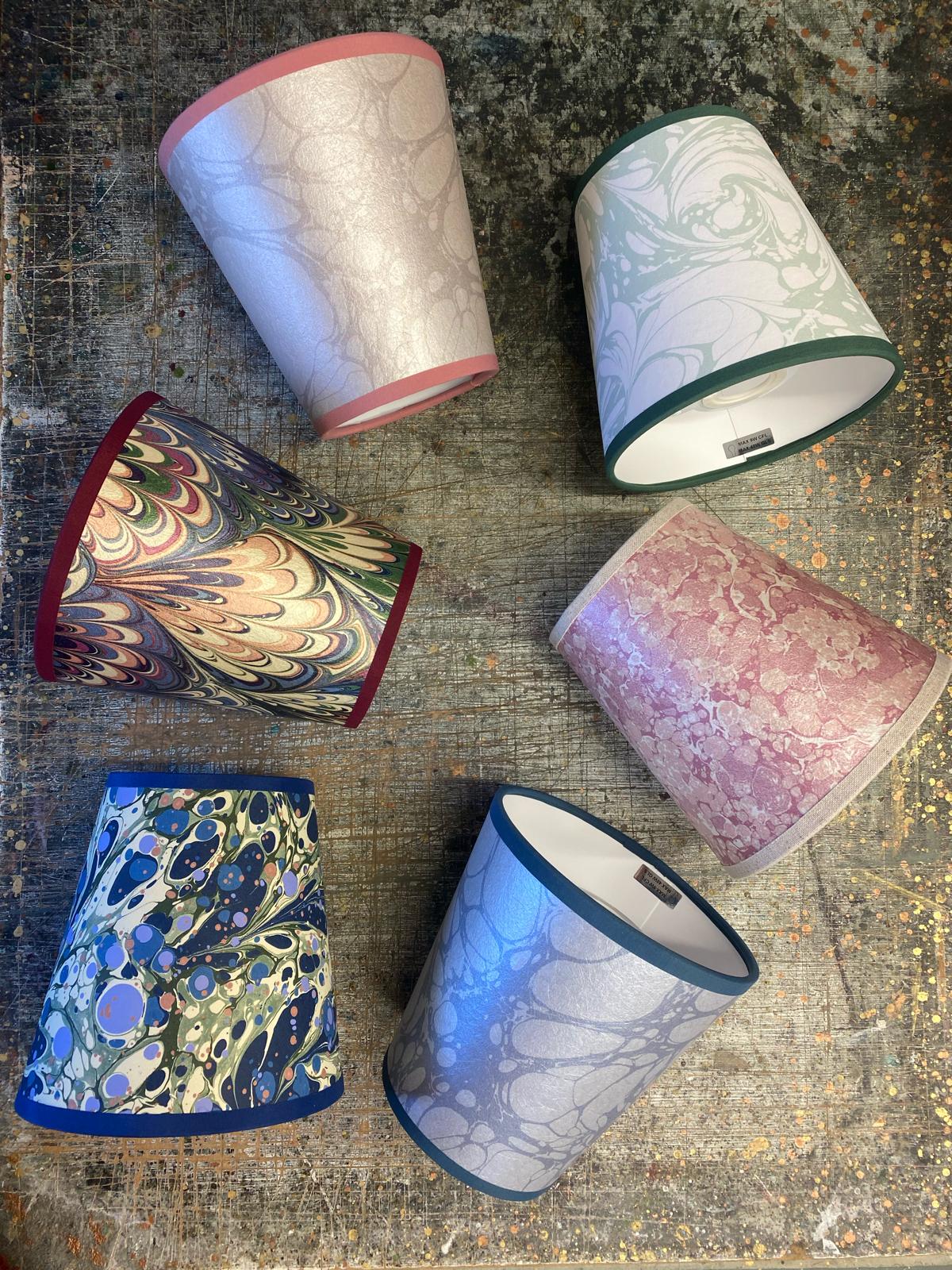 A selection of House of Amitié marbled printed paper lampshades shown within Jemma's Wiltshire workshop.